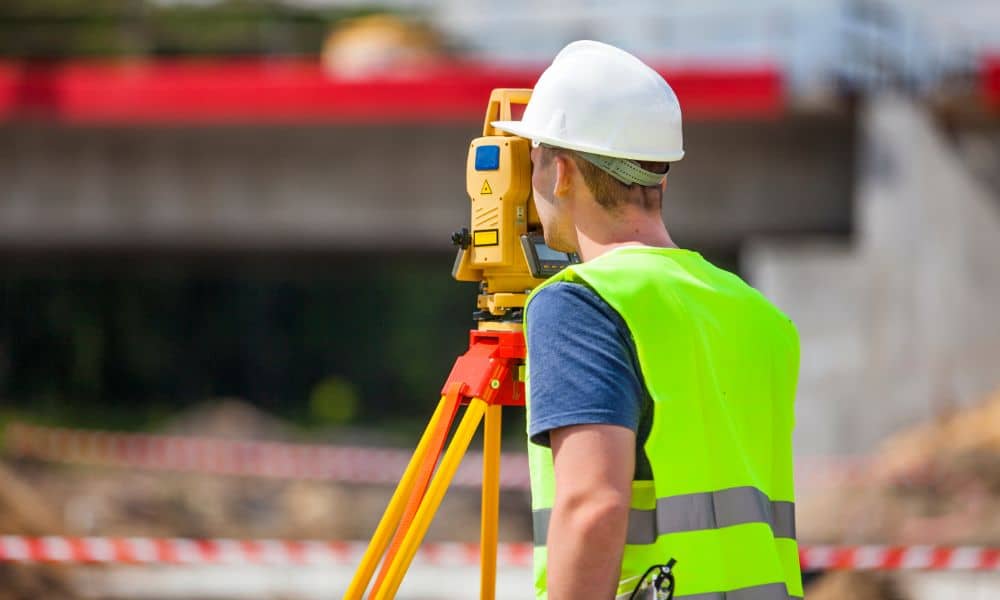 property line survey - Land surveyor using total station to measure property boundaries in Lafayette, AL.
