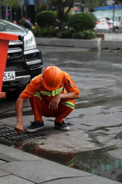 Civil engineering worker inspecting a storm drain to improve site drainage in Birmingham
