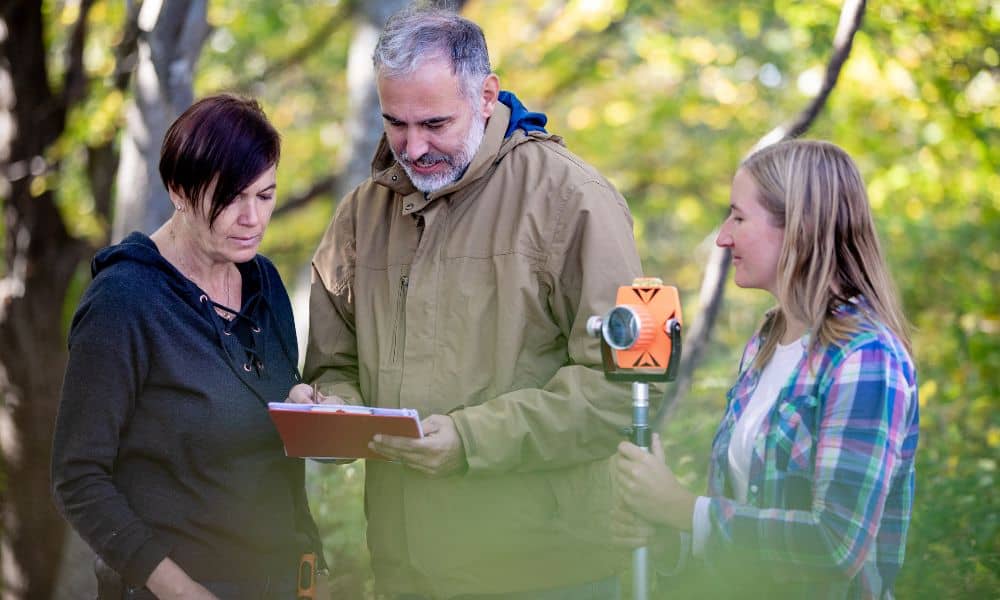 Homeowners meeting with a land surveyor during a boundary line survey to review property boundaries
