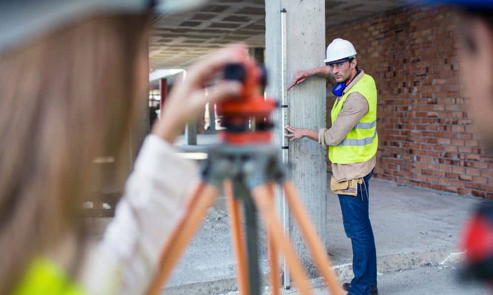 Land surveyors conducting an ALTA Land Title Survey on a commercial construction site before development begins