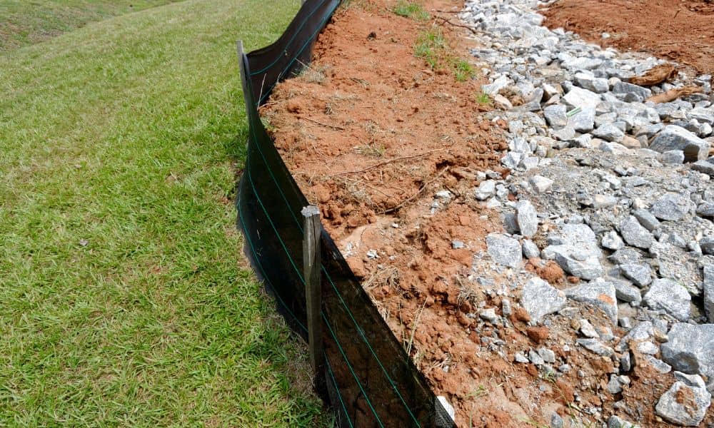 Erosion control barrier along a construction site showing how construction survey accuracy supports stormwater compliance