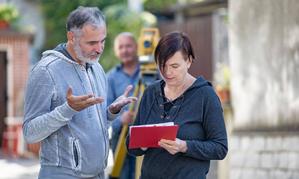 Homeowner reviewing plans with a land surveyor as part of a boundary survey before starting a building project