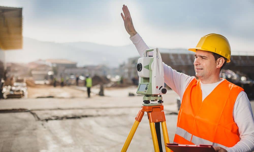 Licensed land surveyor performing an ALTA land title survey to verify property conditions before closing
