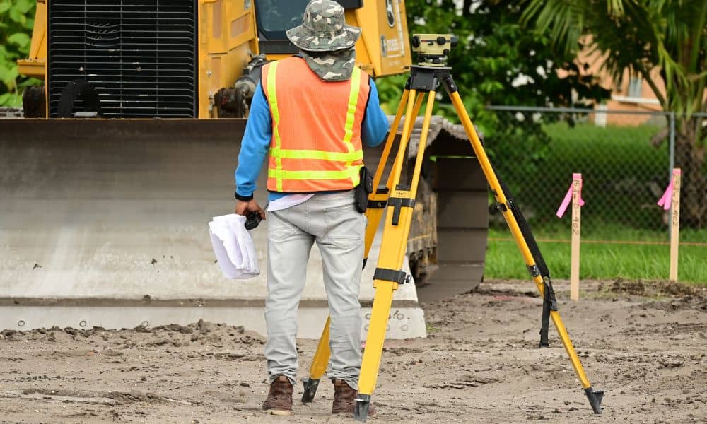 Construction staking showing a surveyor setting site layout before building begins