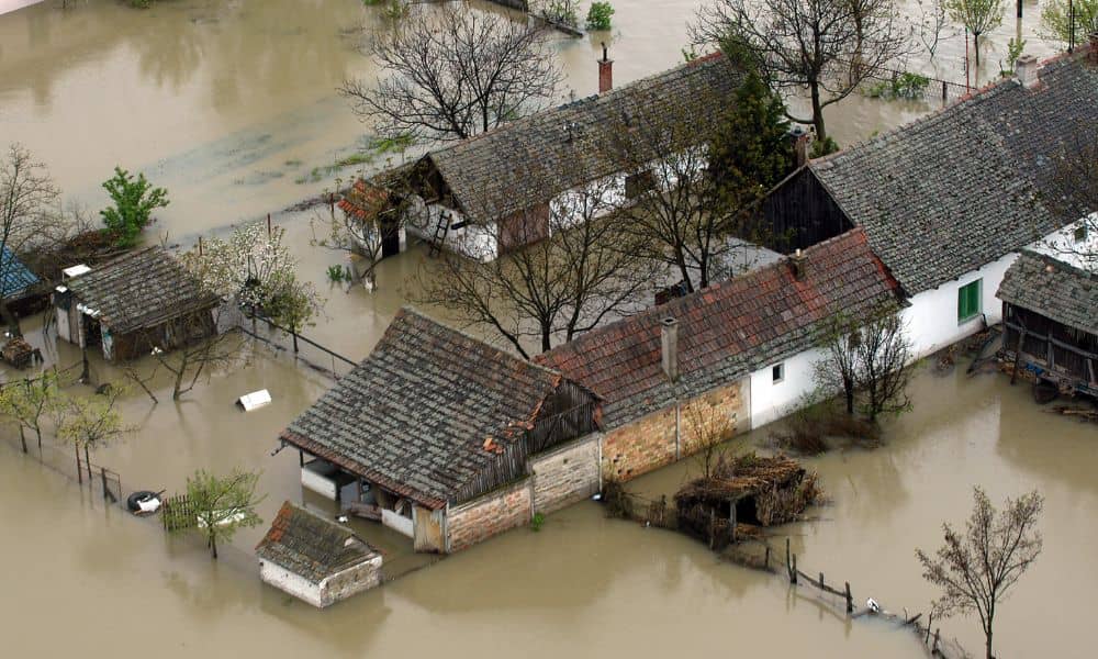 Residential flooding poor drainage aerial view - ALTA Survey Alabama Aerial view of residential homes surrounded by floodwater, showing how a topo survey helps identify low-lying areas and drainage issues