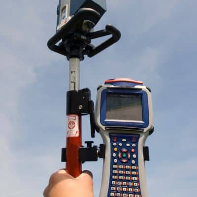 Surveyor using RTK GPS rover and data collector to maintain stable corrections in the field