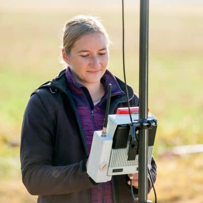 Surveyor using GPS equipment to collect measurements that affect property survey cost