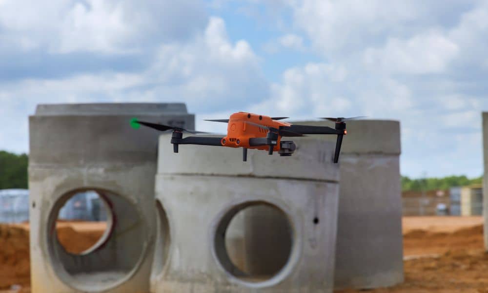 Drone surveying equipment flying above a construction development site with concrete drainage structures