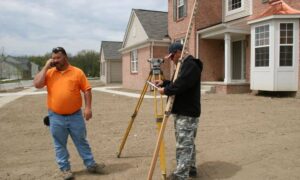 Surveyor measuring near a house to check property boundaries