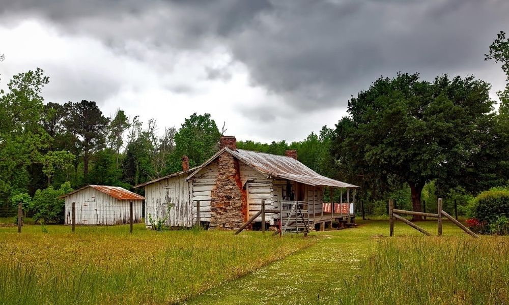 Rural homesite with a house, open grassy yard, and surrounding trees for lot survey planning